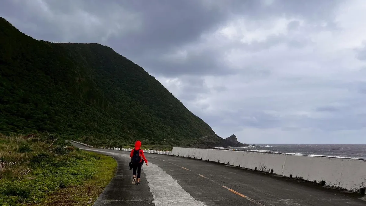 夥伴沿著海岸公路行走,左側是山壁、右側是海