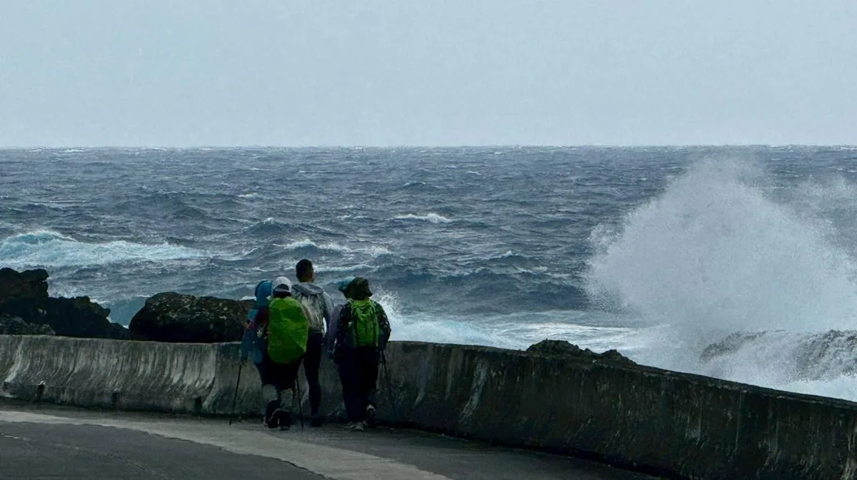 浪花打上堤岸,夥伴走在濱海公路上
