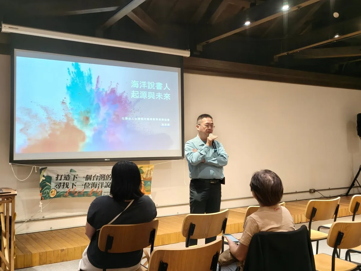 講者站在台前演講,投影幕顯示「海洋說書人 起源與未來」,台下學員聆聽