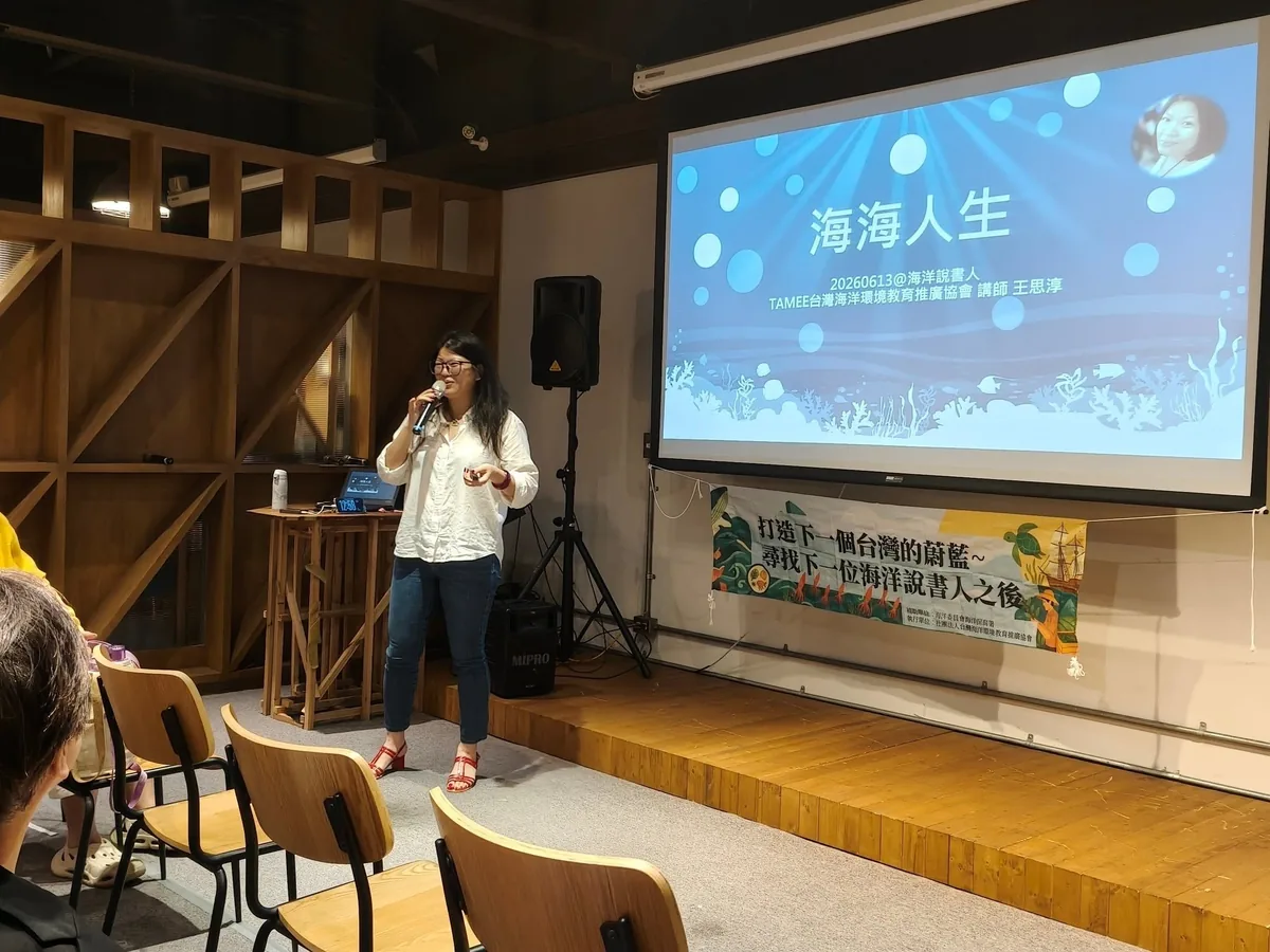 講師拿著麥克風在台前分享,投影幕顯示課程主題「海海人生」